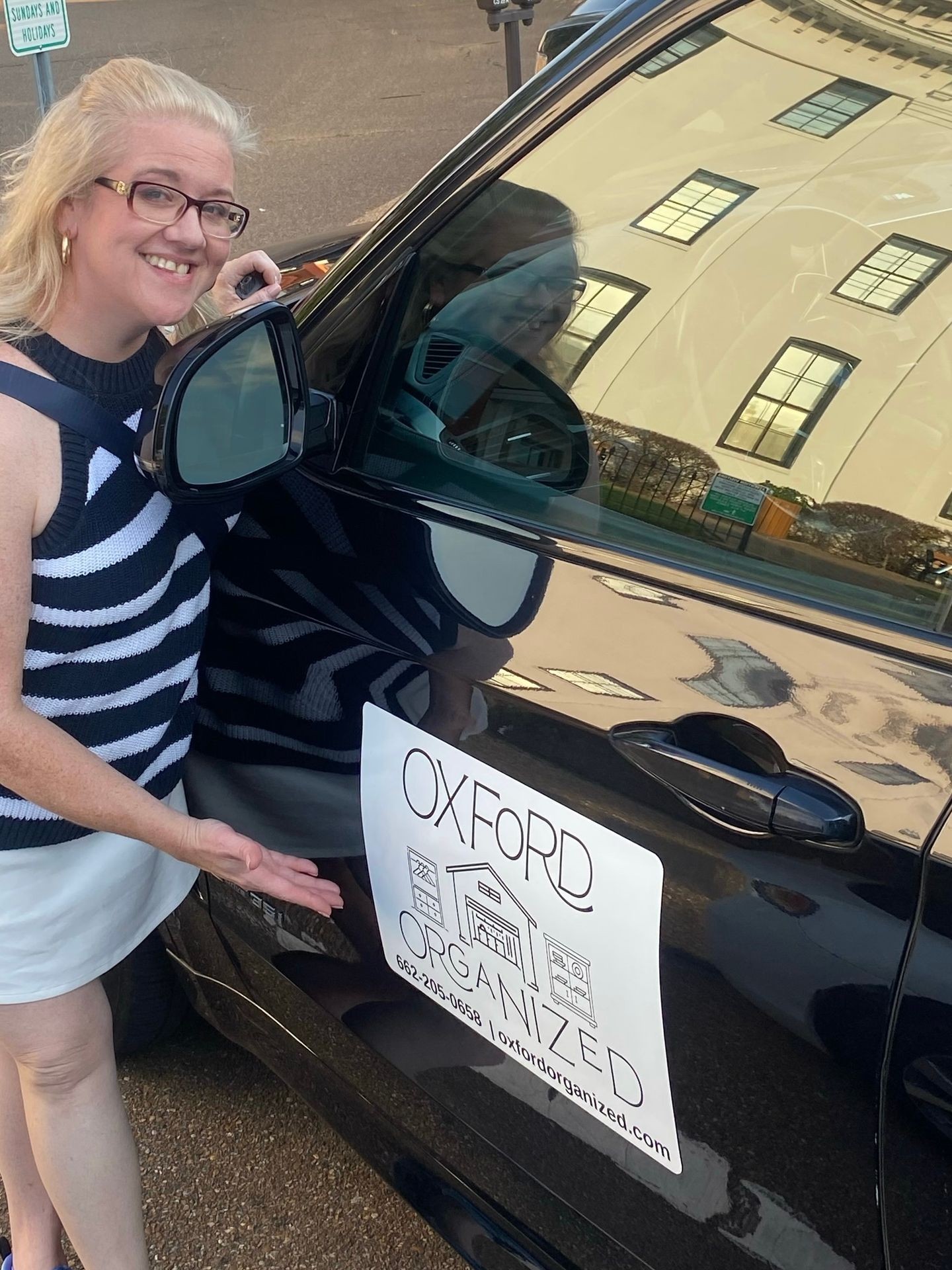 Owner of Oxford Organized pointing to logo sign in Oxford MS